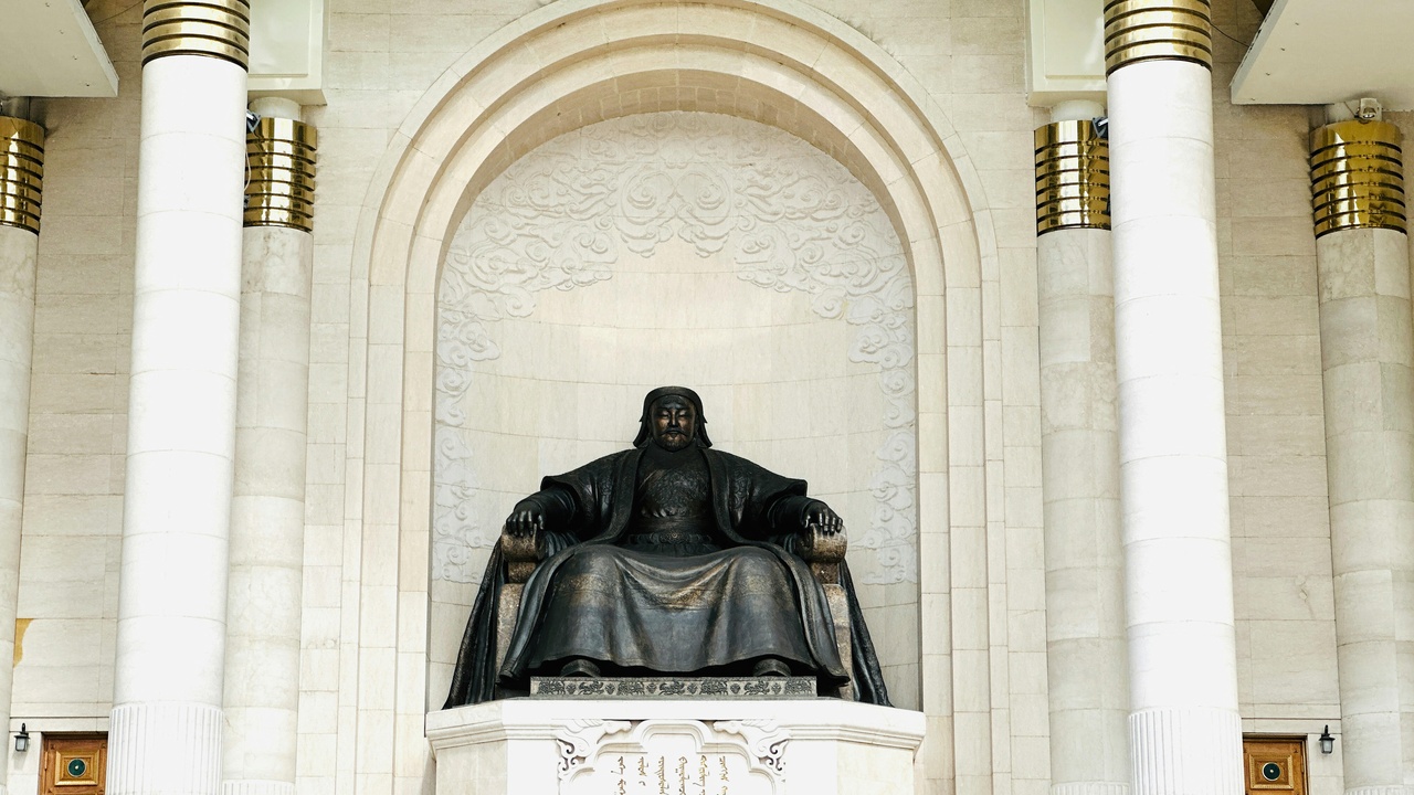 Statue of Genghis Khan with map of Mongol Empire and Erdene Zuu monastery in the background