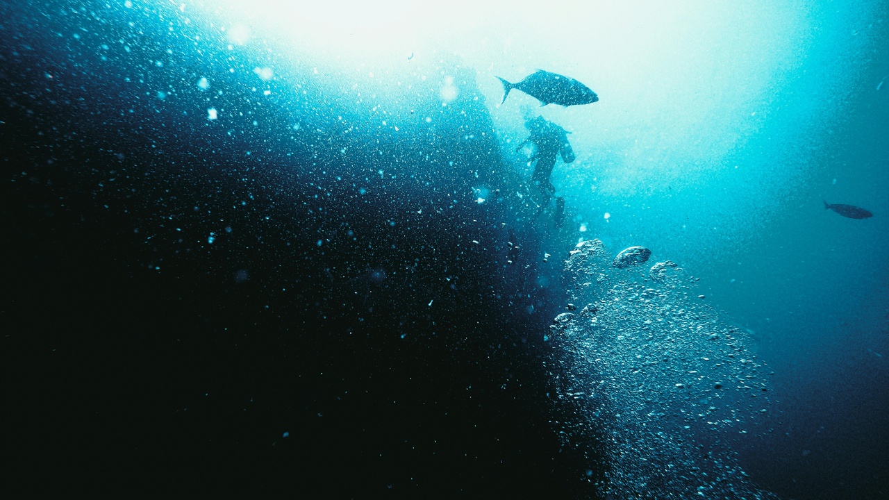 Scuba diver exploring a WWII wreck off Palau with clear water and coral growth