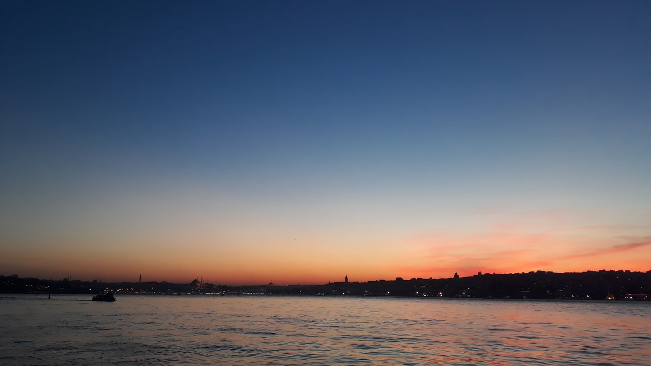 Sunset over the Bosphorus with Istanbul skyline and boats on the water
