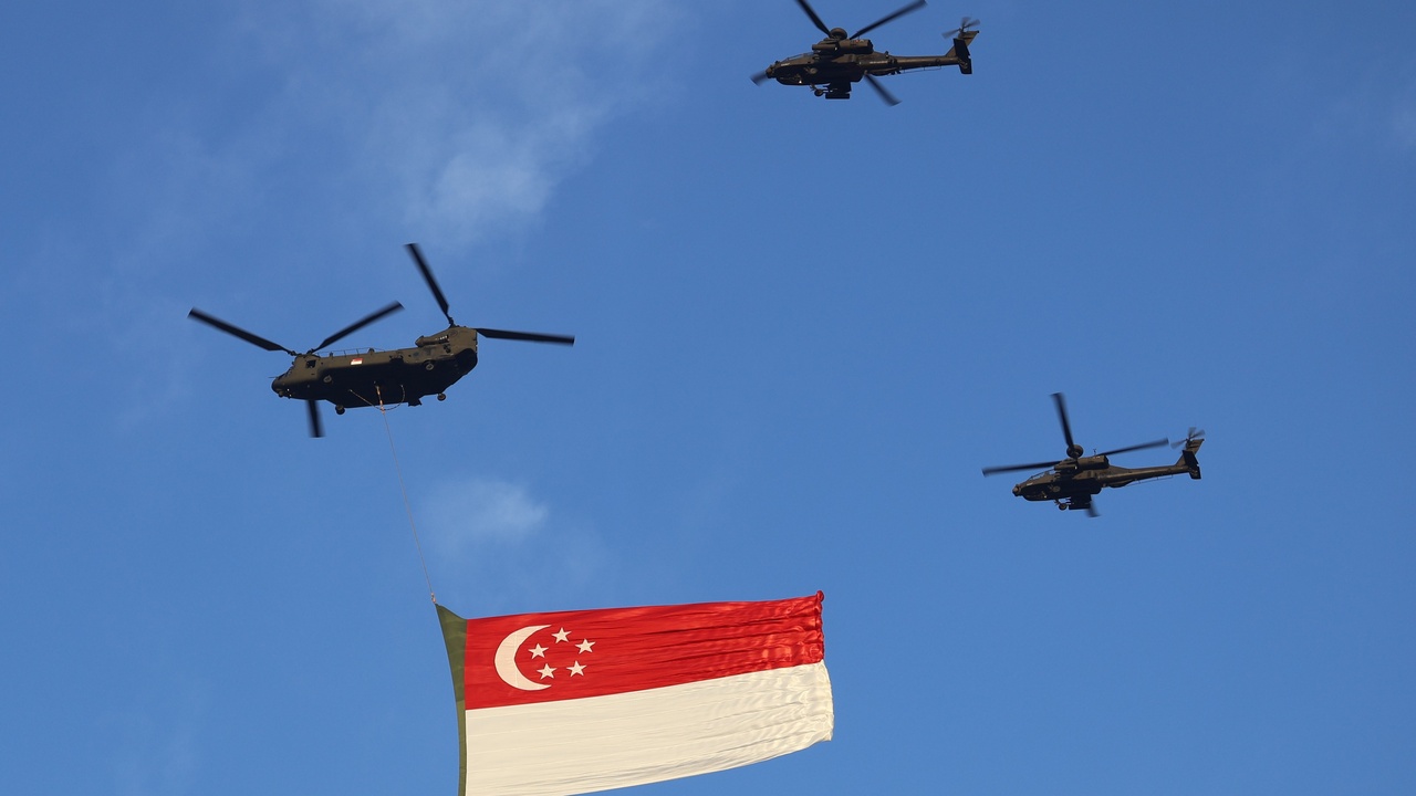 Fireworks and crowd at Marina Bay during National Day Parade with flags and performances