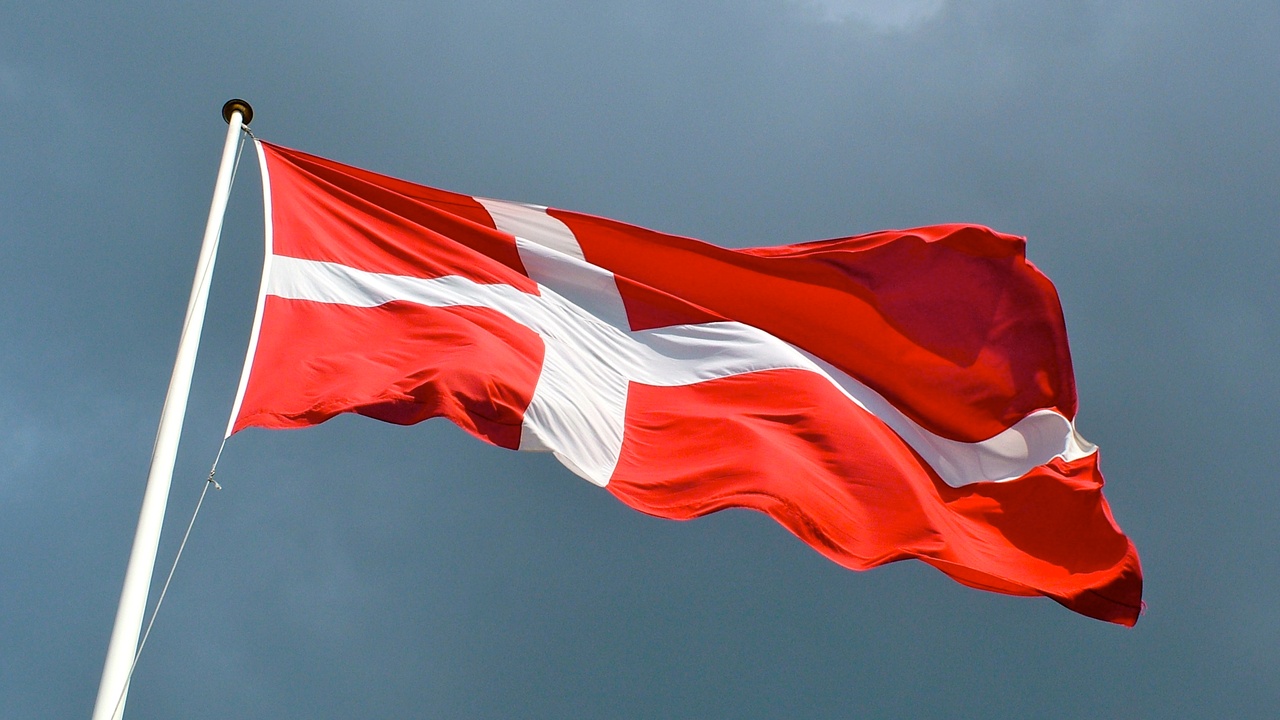 Dannebrog flag flying over public building and folk high school students outdoors