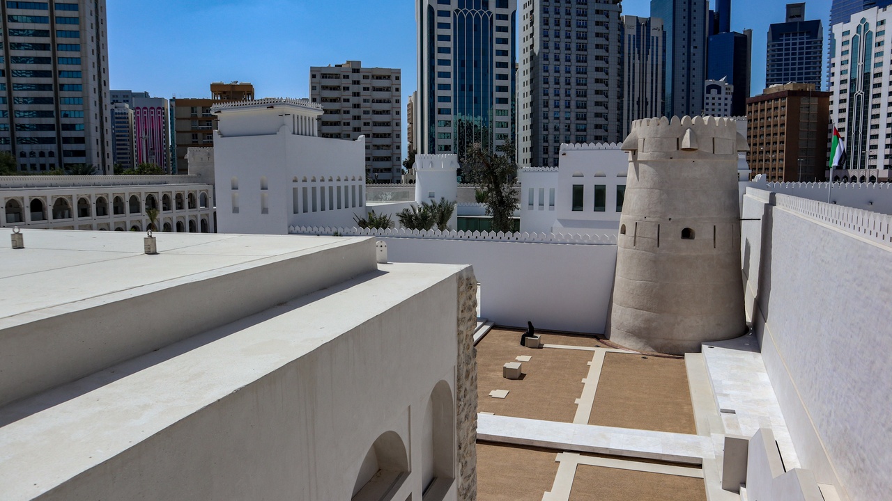 Visitors at Sheikh Zayed Grand Mosque admiring white marble domes