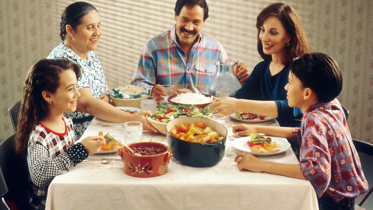 Extended Dominican family gathered around a table for a Sunday meal.