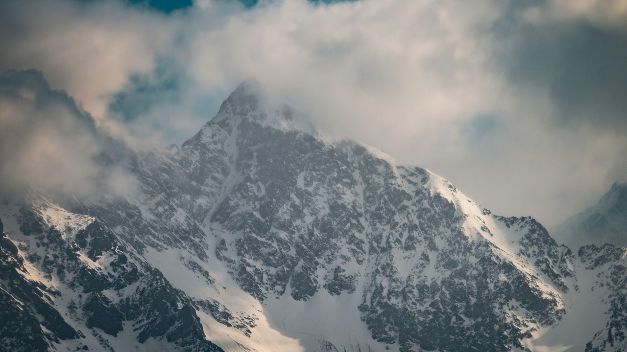 Snow-capped Swiss Alps with a scenic train in the foreground.