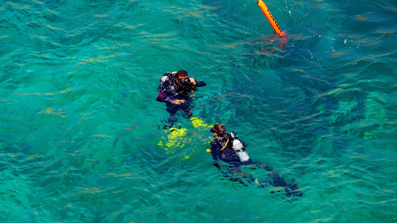 Clear turquoise waters around the Tobago Cays with snorkelers and sailboats