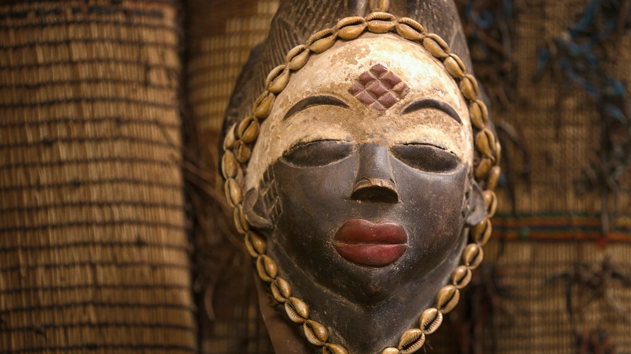 Artisan carving a traditional mask in an Equatorial Guinea workshop.