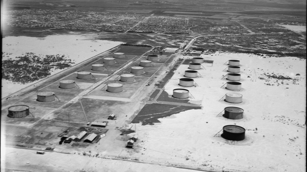 Oil pumps and cranes at Basra port, illustrating Iraq's economic activity