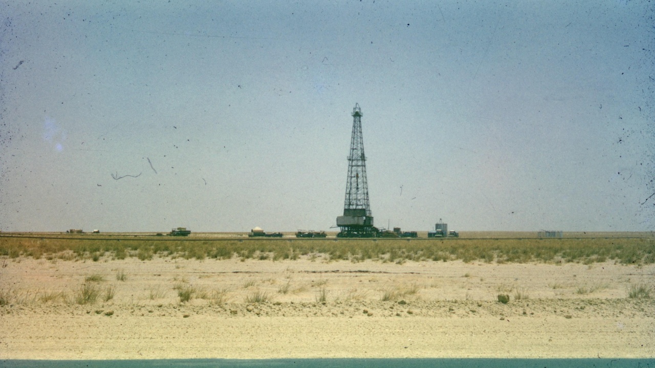 Kuwaiti oil facilities at sunrise with national flag in foreground