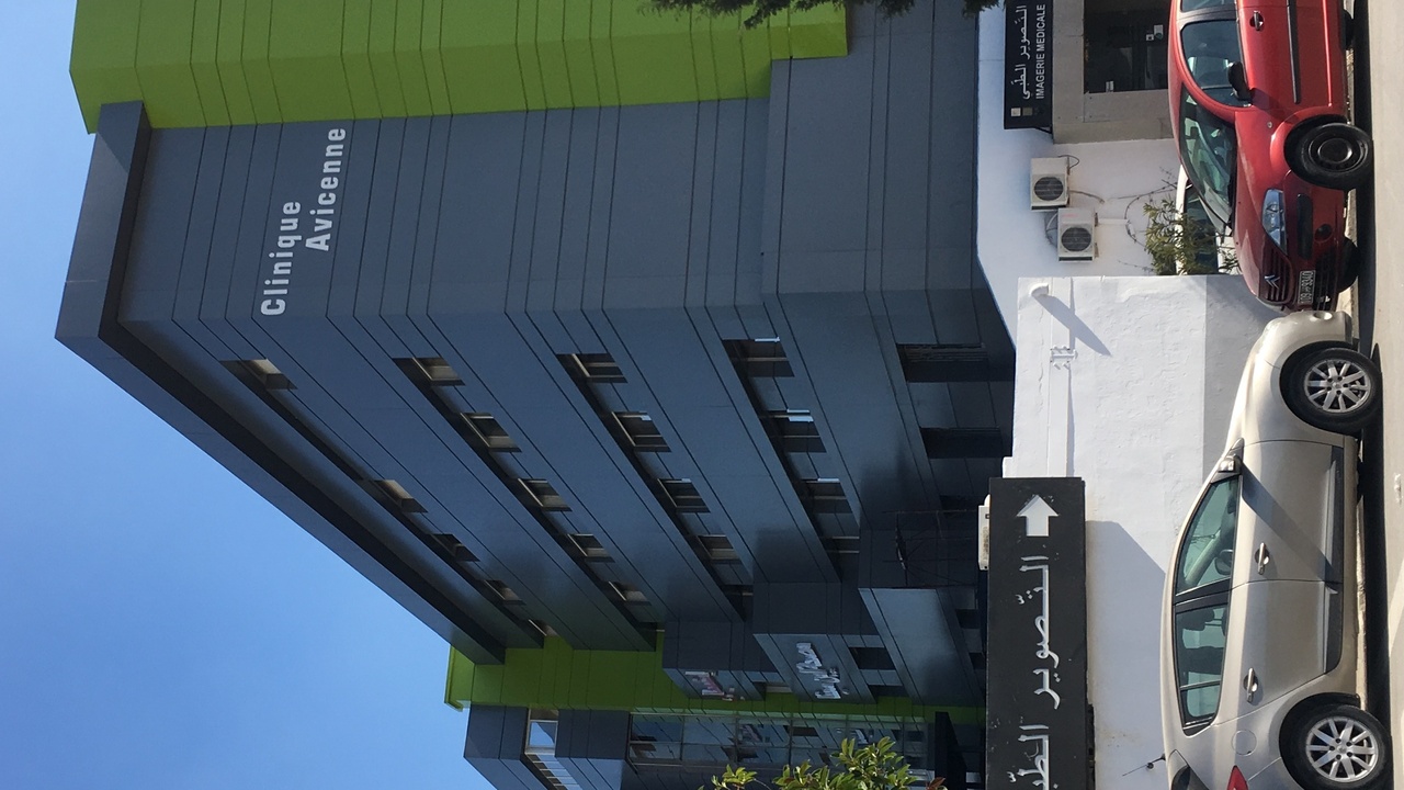 Modern hospital entrance in Tunis with ambulances and staff
