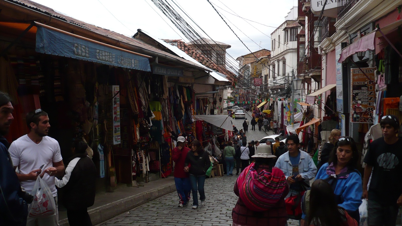 Stalls at a busy La Paz market with textiles and local produce