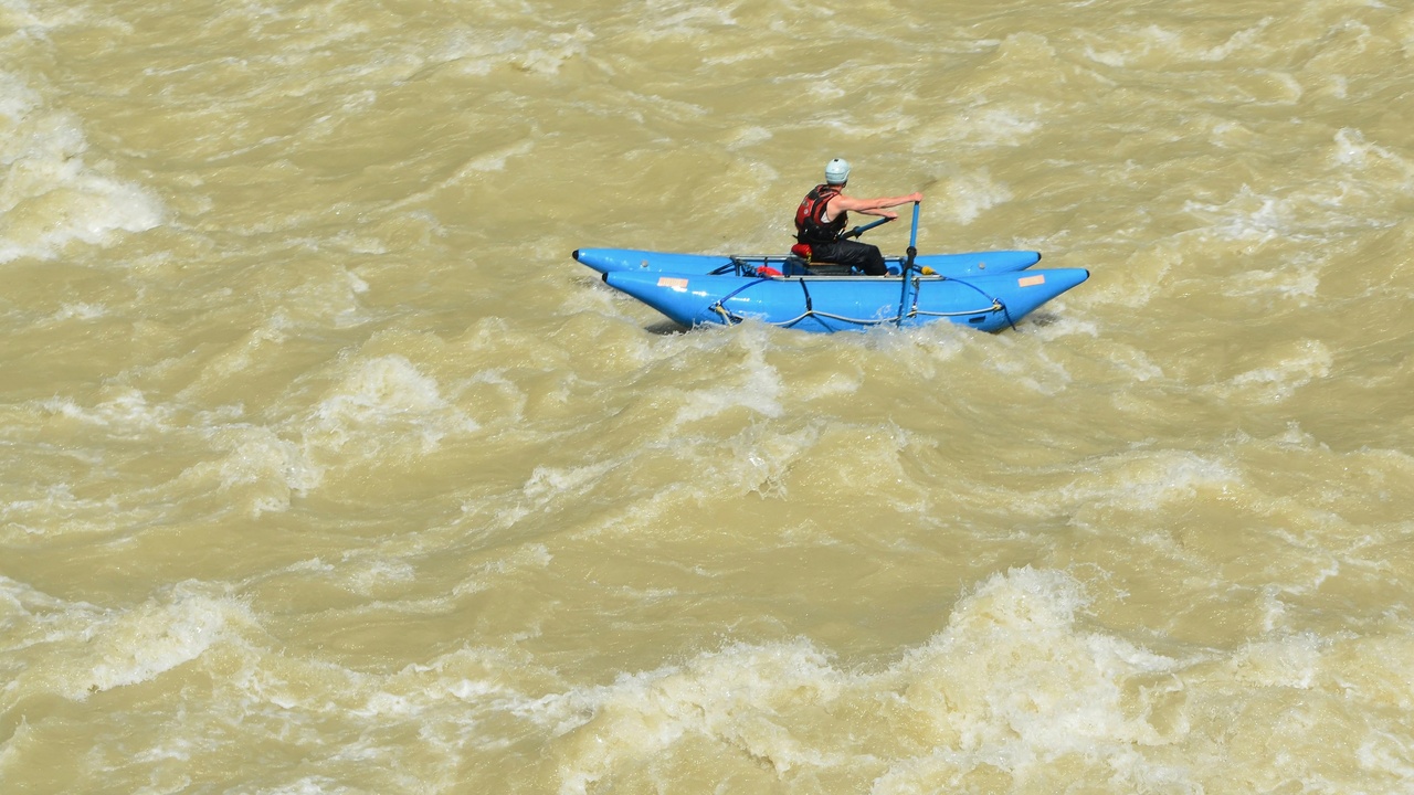 Kayakers paddling on the San Antonio River Reach with city trees and mission landscape in view.