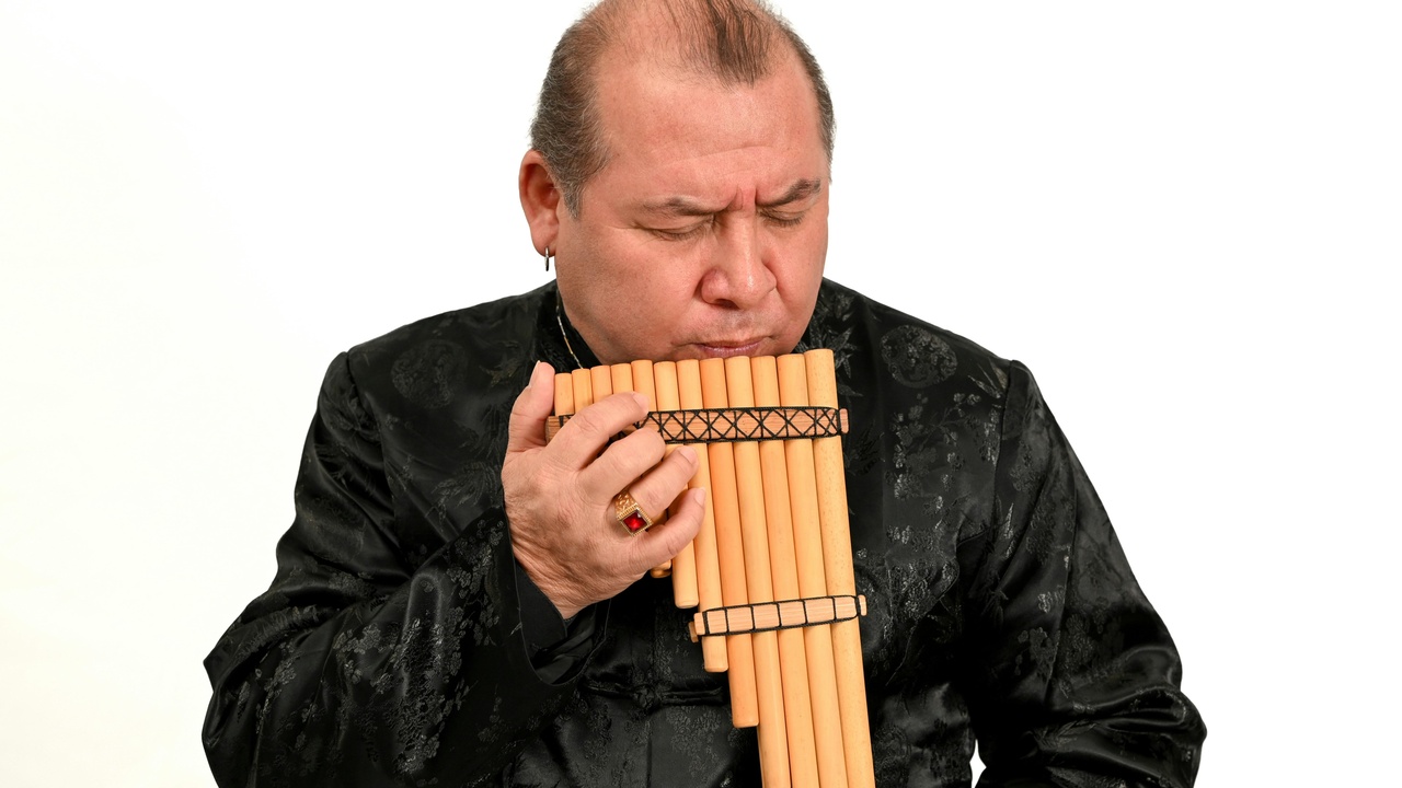 Duduk player performing near a collection of carved khachkar stones