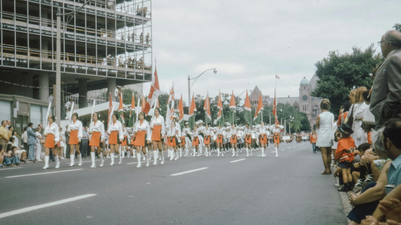 Spicemas parade with costumed dancers and spectators