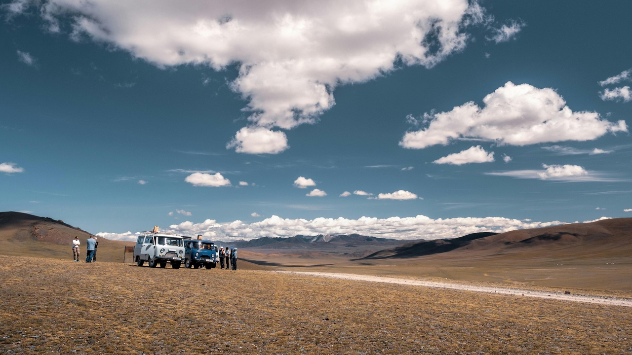 A 4x4 vehicle on a rugged Mongolian track with a frozen Lake Khuvsgul scene inset