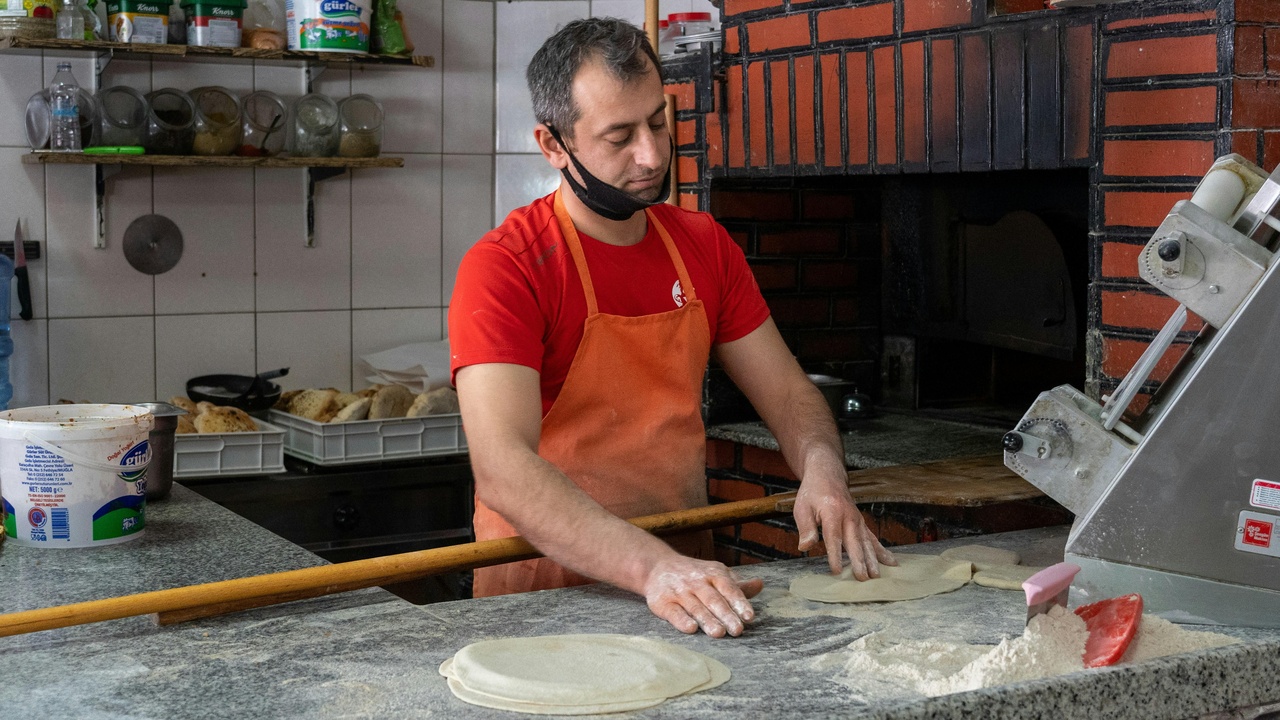 Traditional lavash baking in a tonir oven with villagers preparing dough