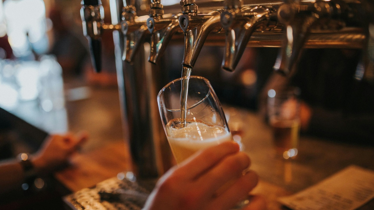 Pilsner beer pouring into a glass alongside traditional Czech dishes