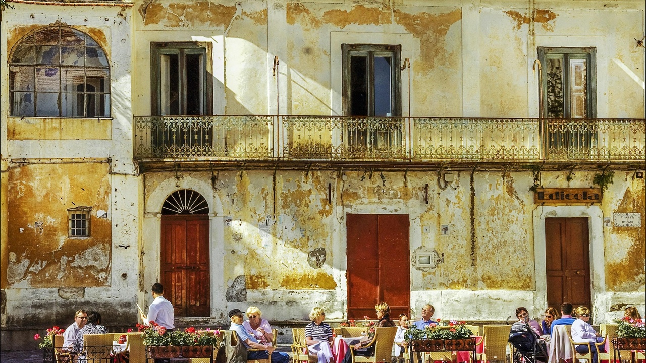 Family gathered around a long table for Sunday lunch in Italy