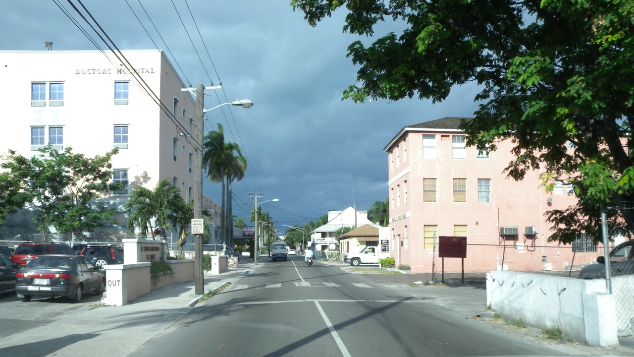 Hospital exterior in Nassau and a calm beach, representing healthcare access and wellbeing in the Bahamas