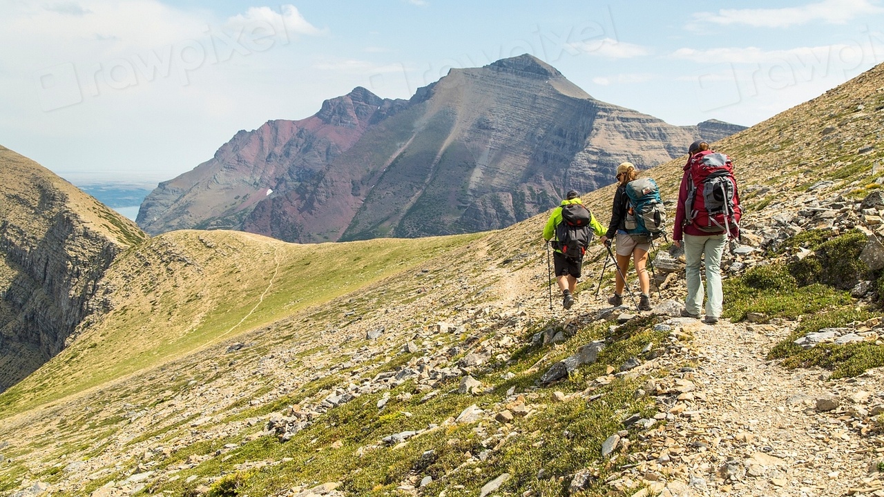 Hikers on a Montana mountain ridge with dramatic peaks in the distance