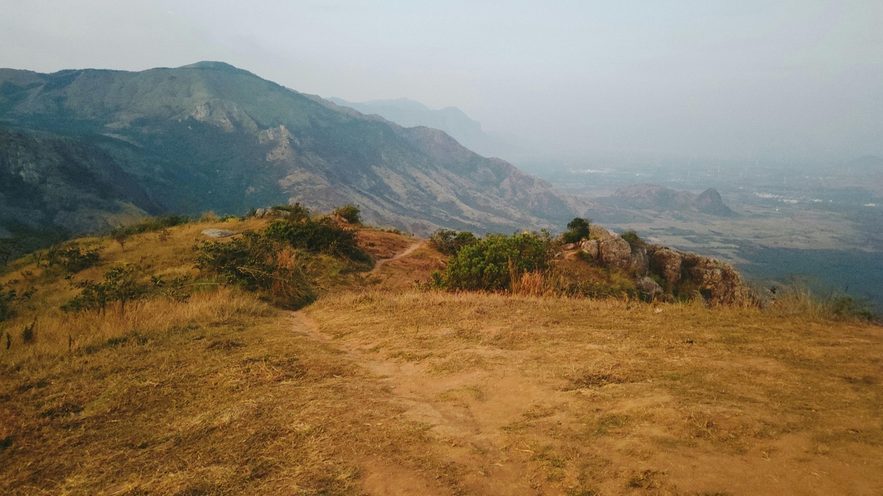 Trekking trail on the Shan Plateau with distant mountains and ethnic villages