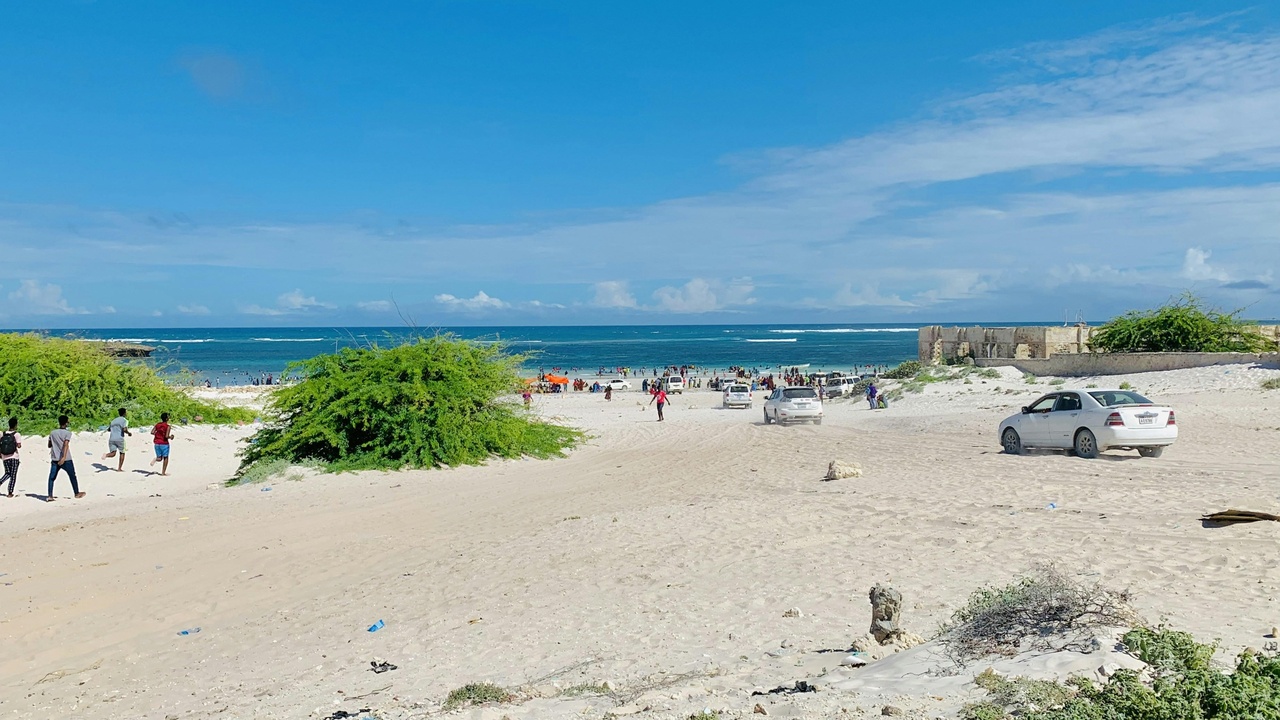 A shore view of Somalia's Indian Ocean coastline with a traditional dhow in the foreground