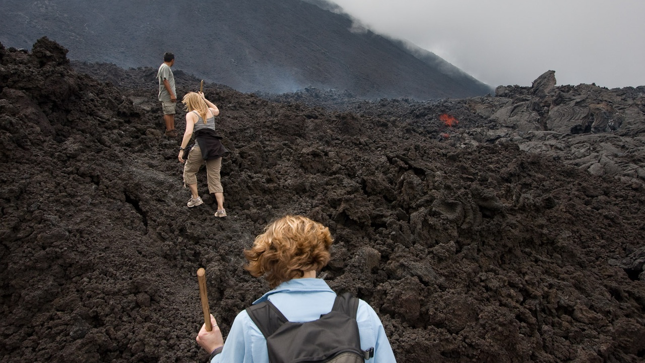 Hikers on Pacaya volcano with nearby green parks and city views