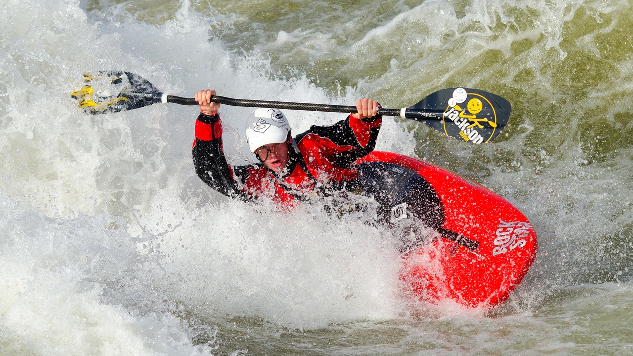 Kayaker paddling a riffle on a scenic forested river in Georgia