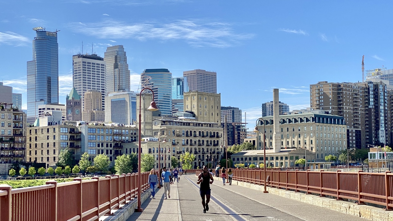 Minneapolis skyline with Stone Arch Bridge over the Mississippi River at sunset