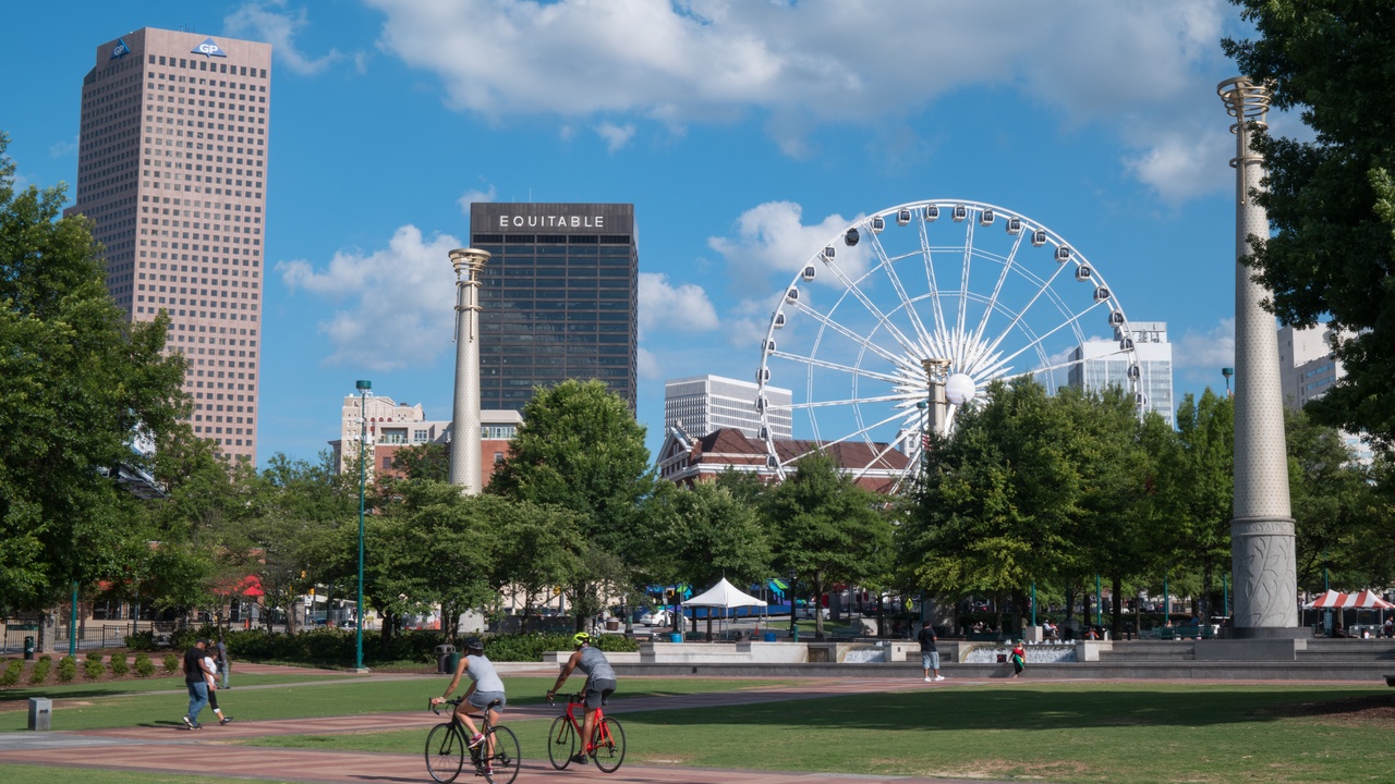 Ferris wheel gondolas over Centennial Olympic Park and an indoor climbing wall