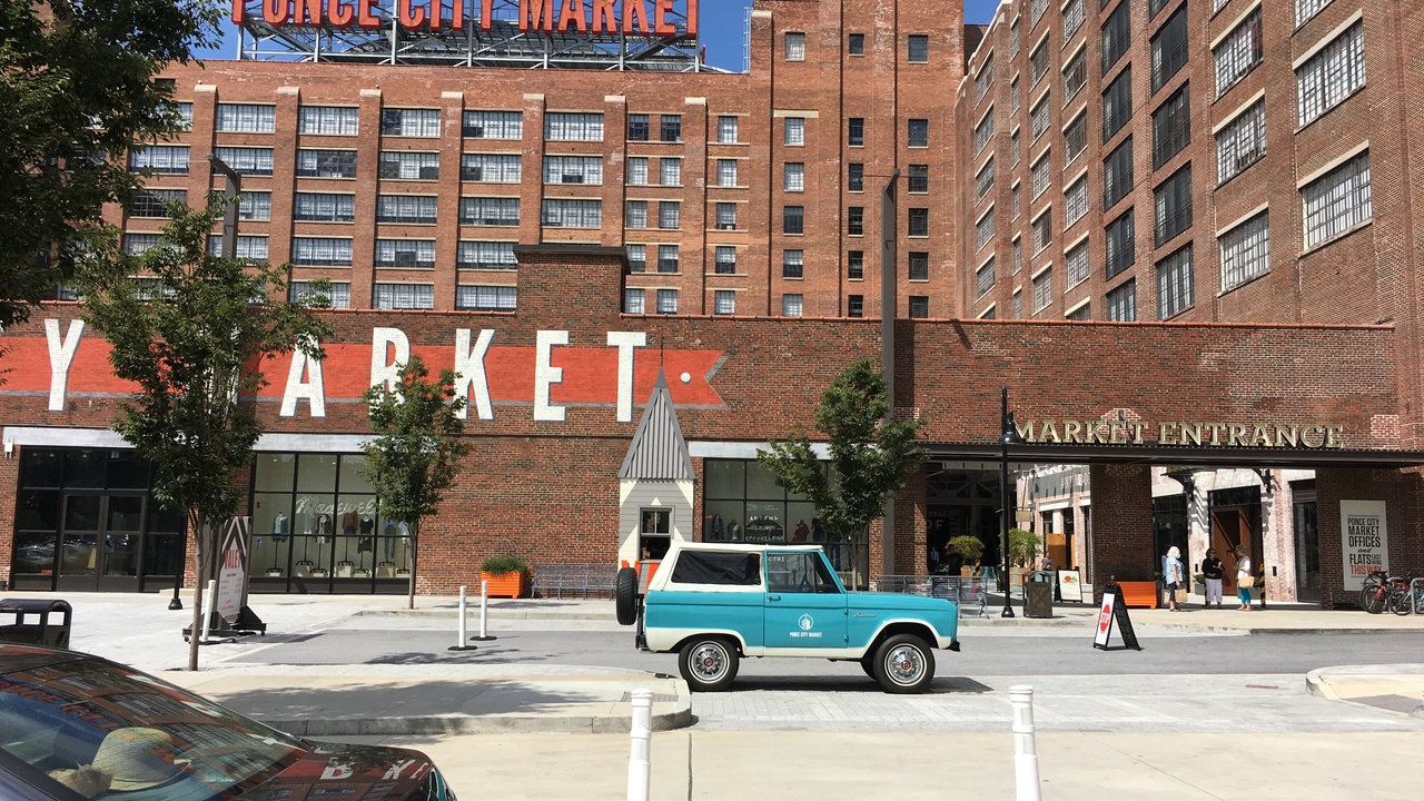 Rooftop view over Atlanta skyline with carnival games and aquarium exhibit nearby