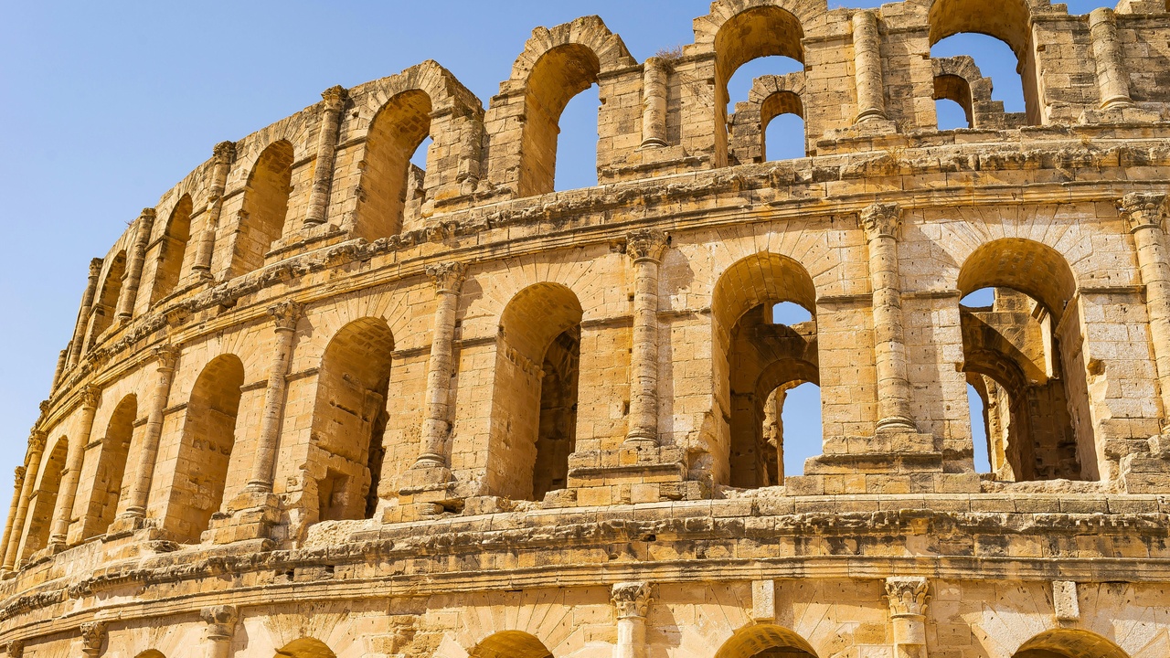Hikers near coastal cliffs and a Roman amphitheatre in Tunisia