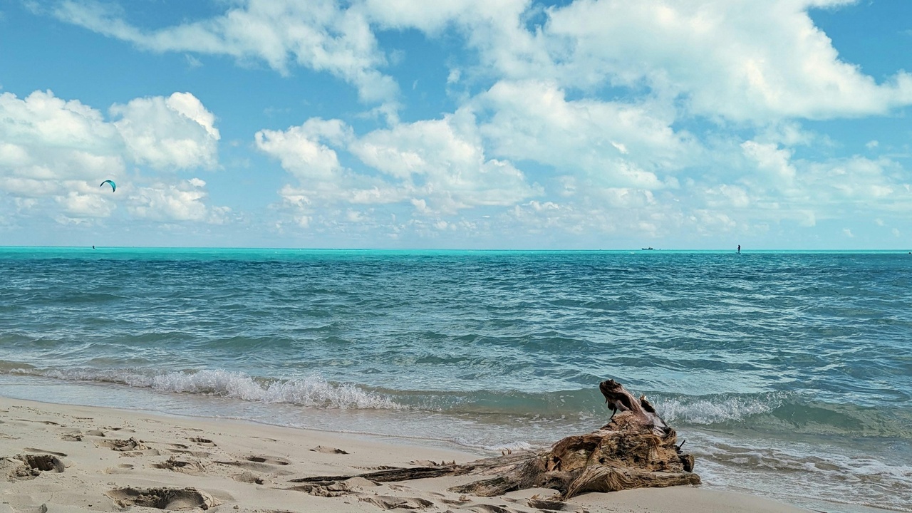 Kitesurfer at Long Bay Beach with a colorful kite