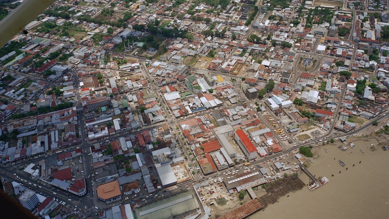 Assortment of Surinamese dishes including roti and pom on a market stall.