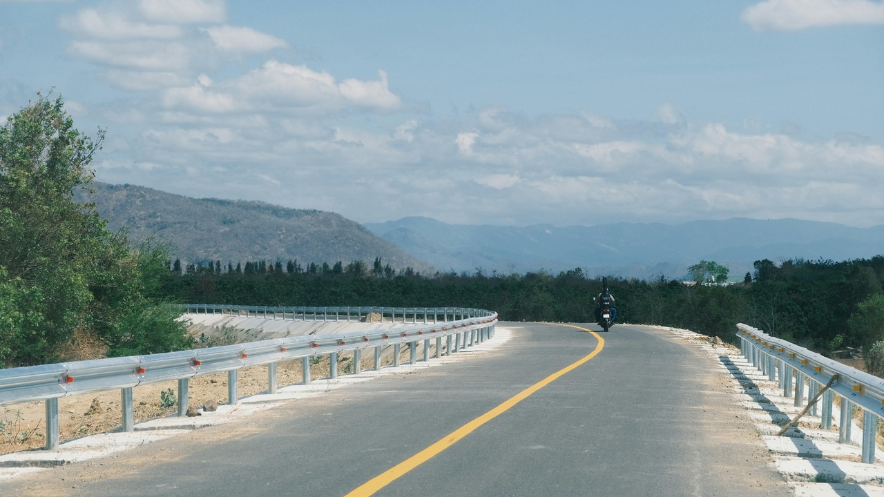 Cyclists on the high road of the Pamir Highway with villages and mountains nearby