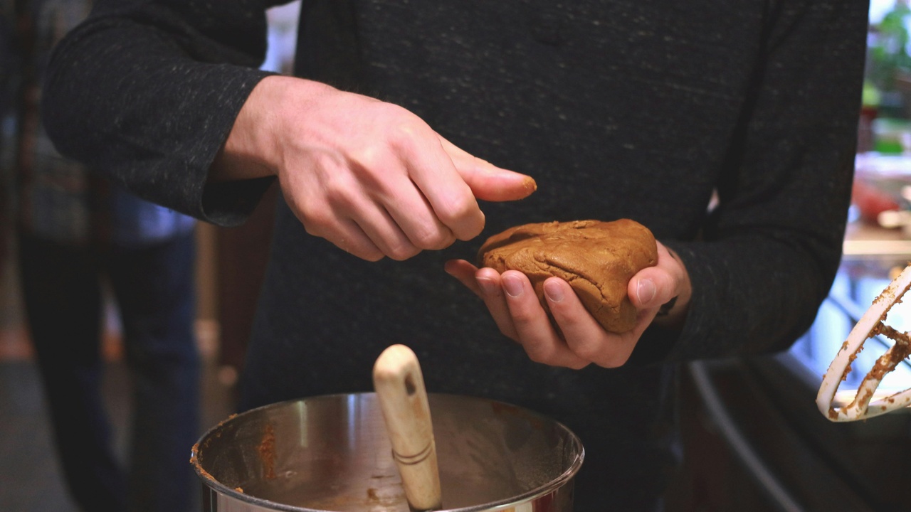 A family preparing pupusas in a home kitchen with ingredients on the table