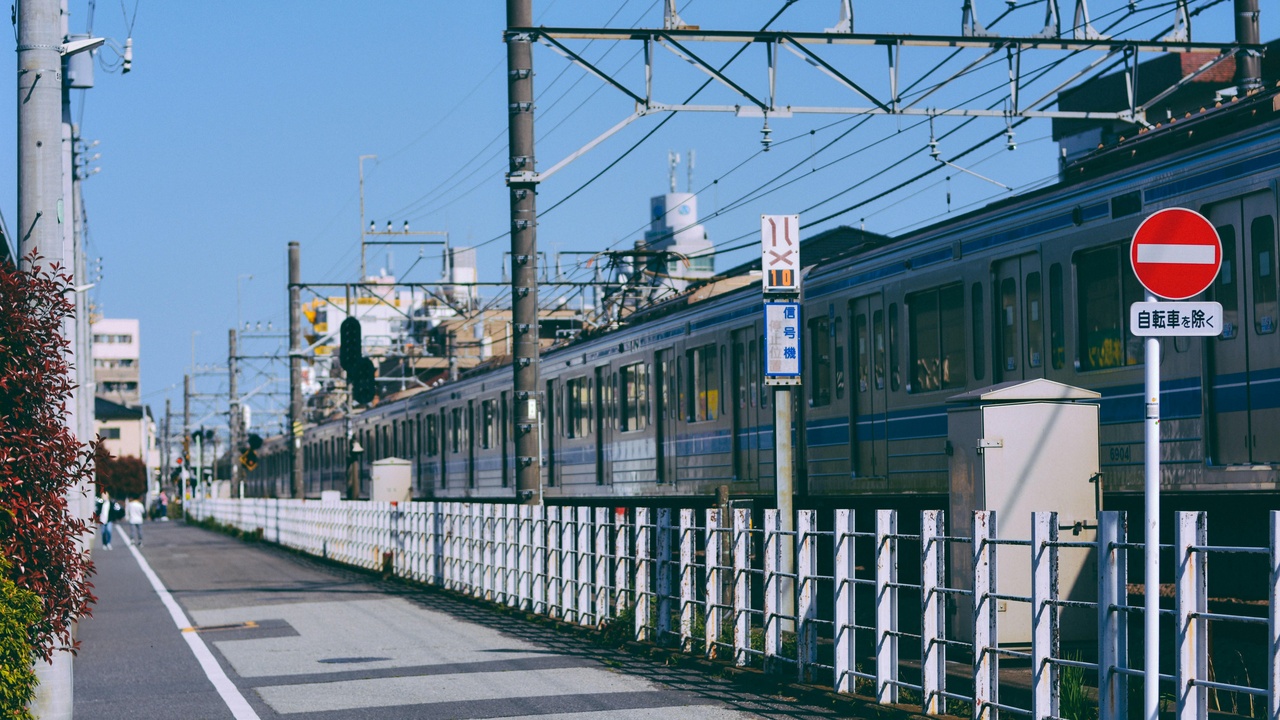 Shinkansen bullet train at a station with urban skyline backdrop