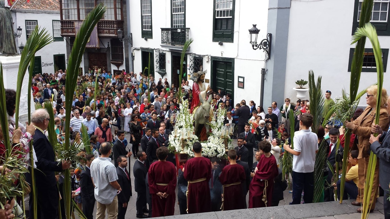 Crowd watching a Semana Santa procession with floats and incense