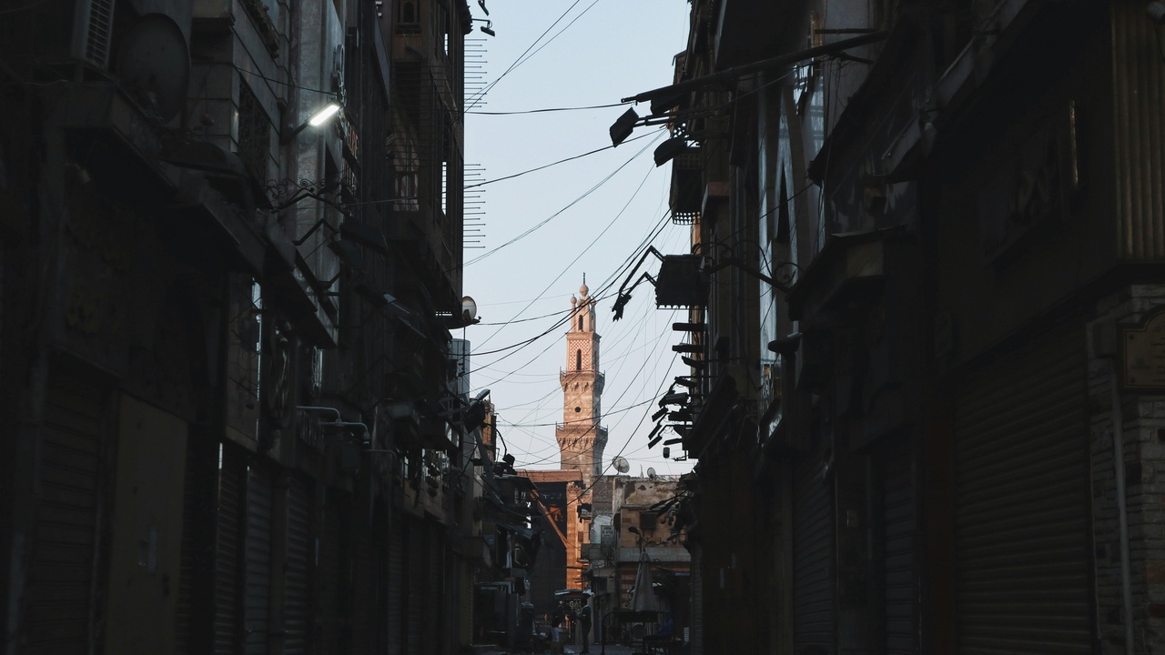 Lantern-lit Cairo street with people breaking fast during Ramadan evenings