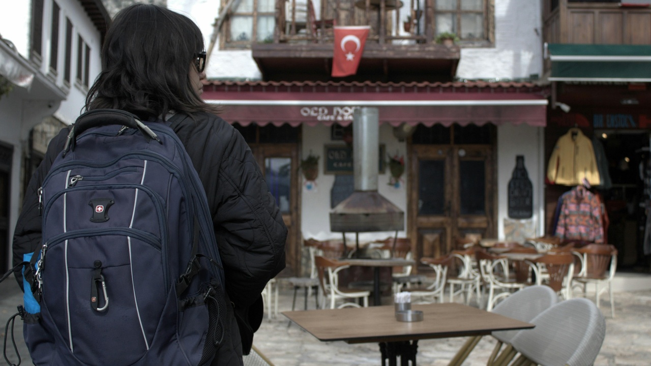 International students socializing on a Turkish campus with cafes and city skyline in the background.