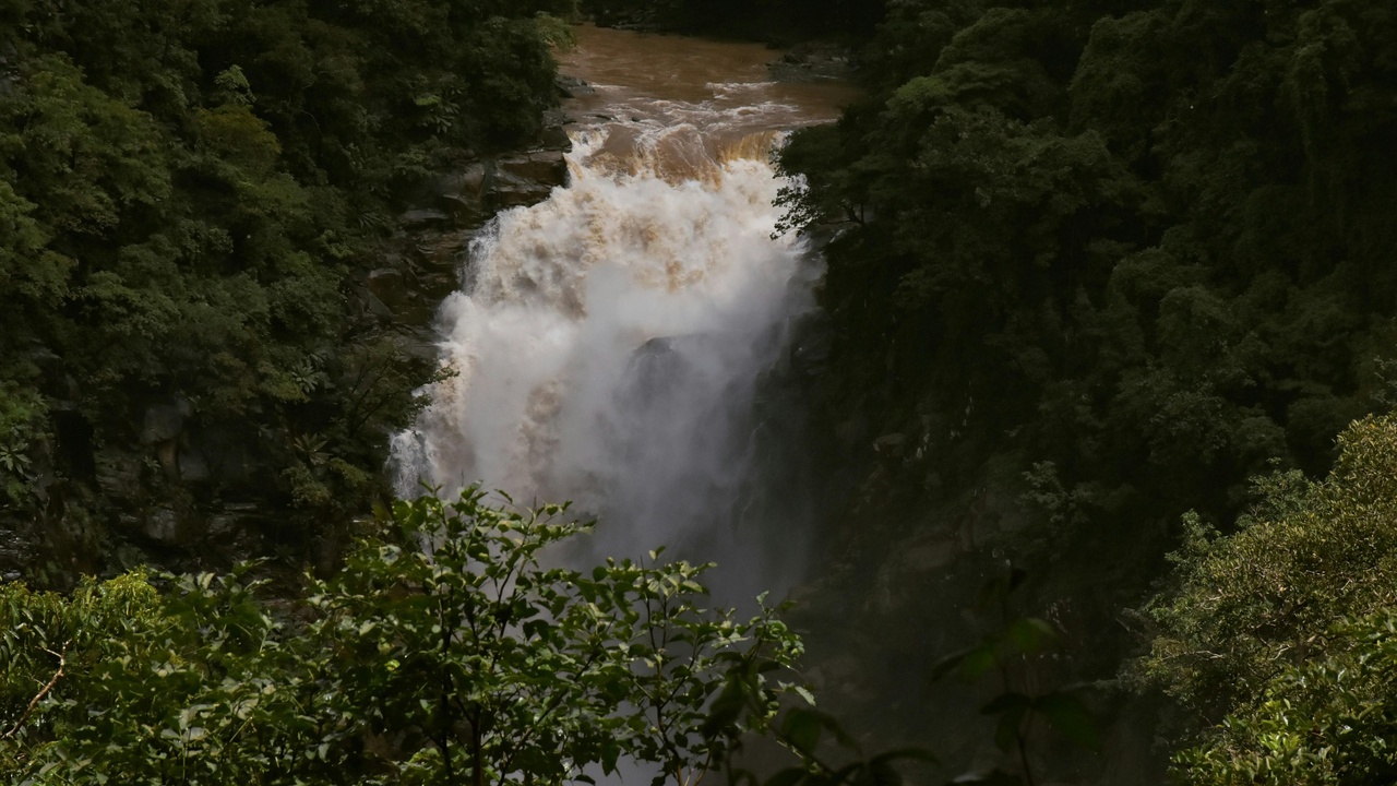 View down a deep canyon toward a tall single‑drop waterfall in Lesotho