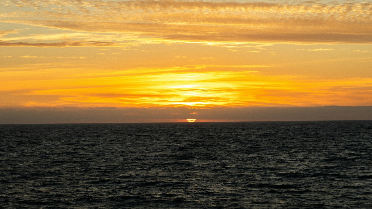 Sunset over Frigate Bay beach, palm trees and calm water