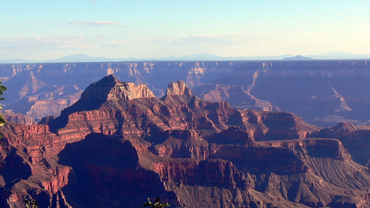 Hikers traversing dramatic canyon rim with sunrise light