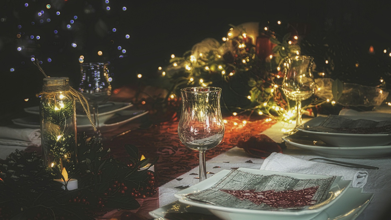 Kūčios table setting and family around the table in Lithuania