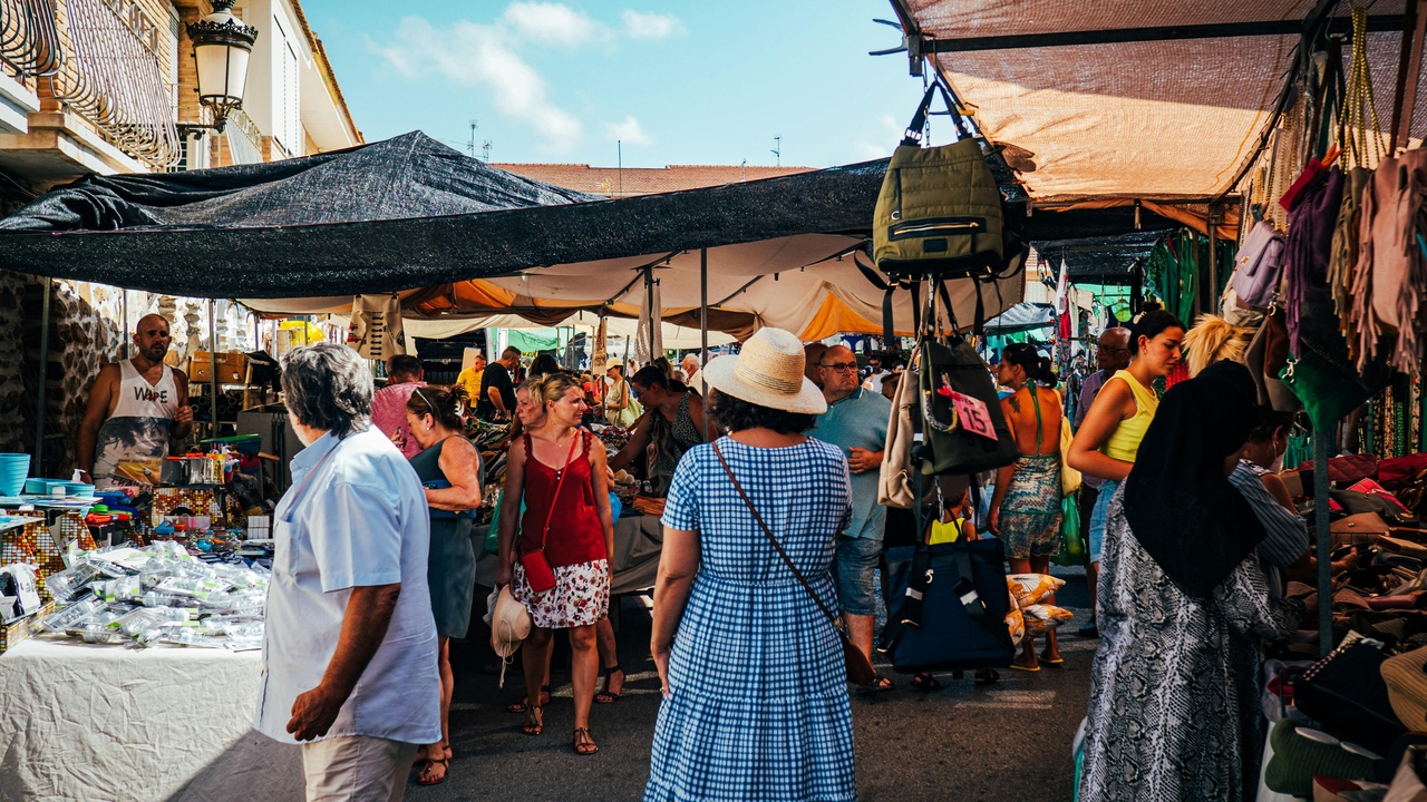 Vendors selling colorful textiles at San Pedro Market in Cusco.