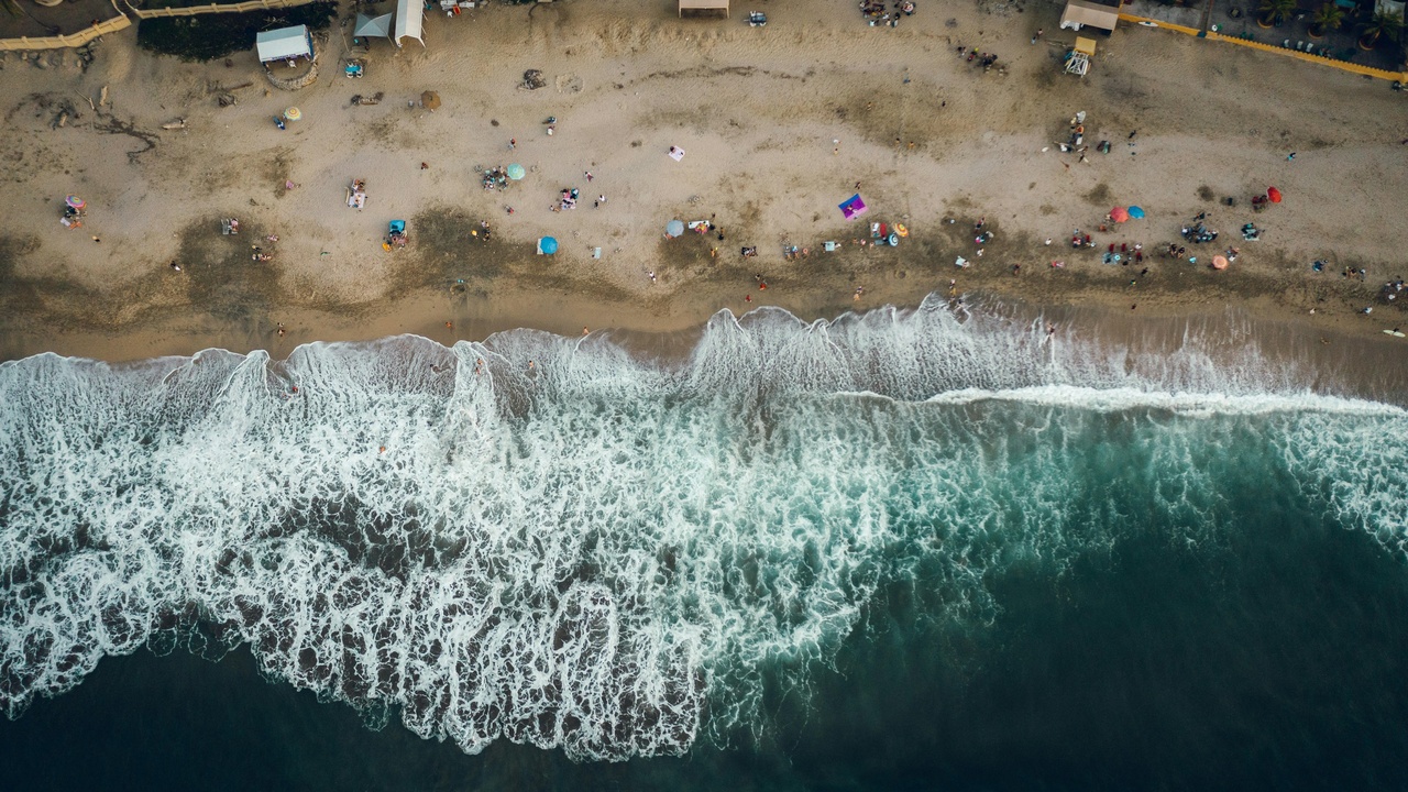 Surfers riding waves at Sayulita beach at sunset