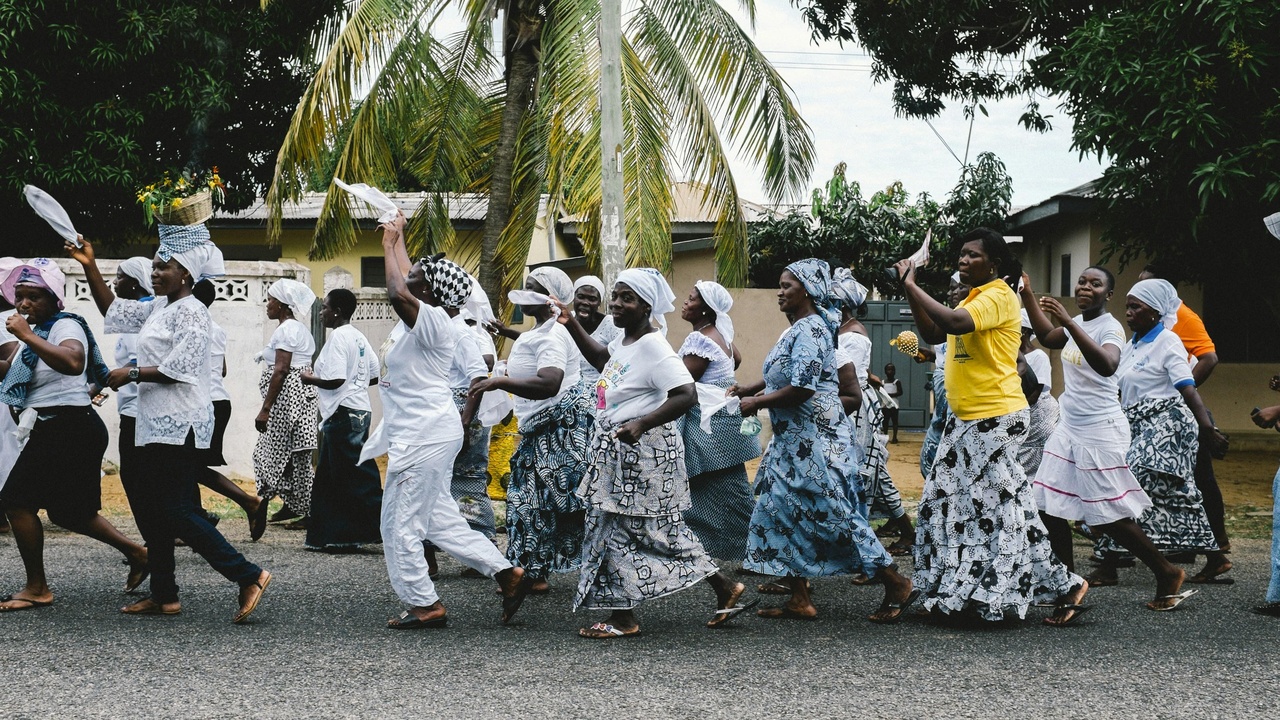 Community gathered at a rural Liberian funeral in daytime