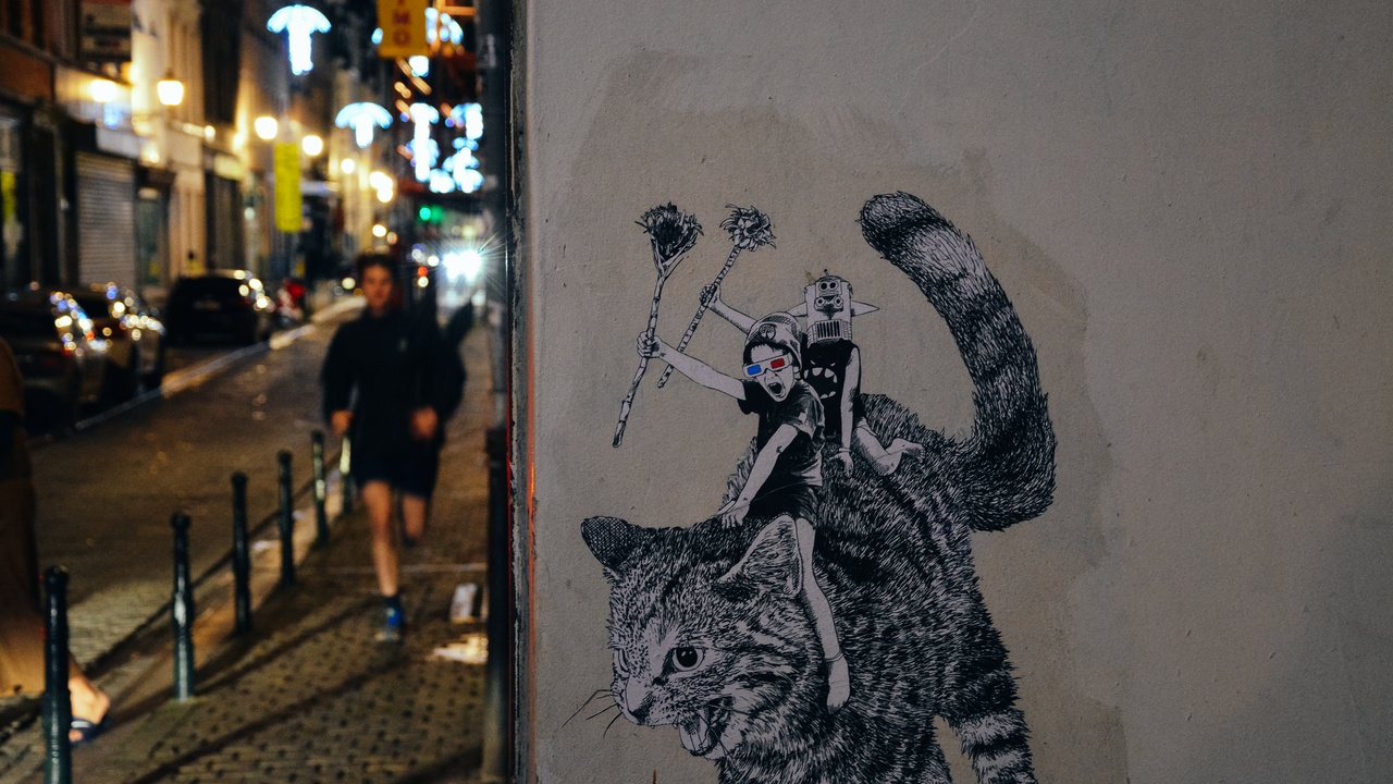 Comic strip mural in Brussels with Magritte painting in background