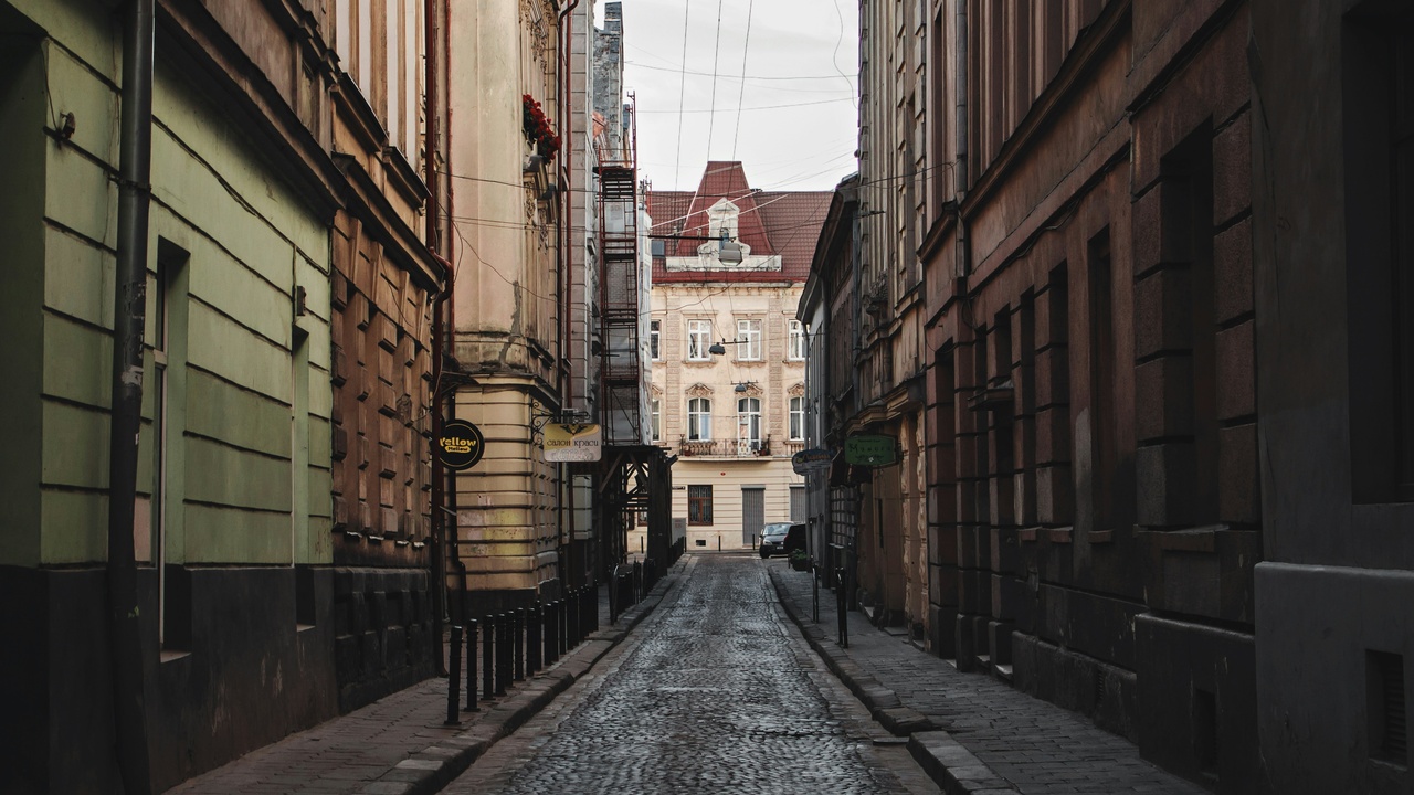 Narrow street in Hanoi's Old Quarter with motorbikes and colonial buildings