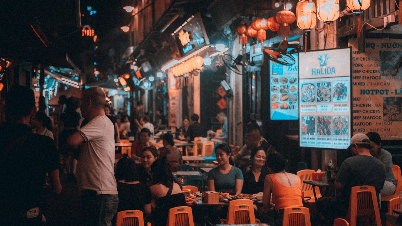 Morning pho stall in Hanoi with steaming bowls and street-side seating.
