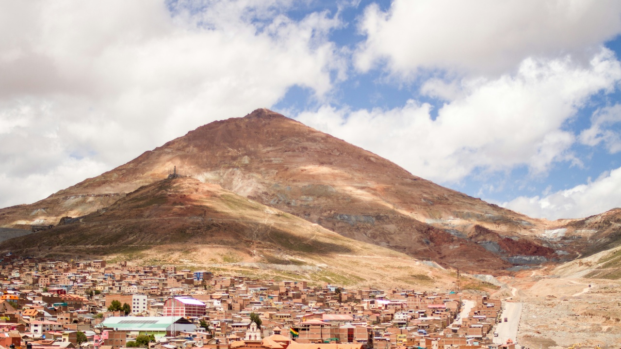 Cerro Rico mine landscape and colonial-era Potosí buildings.
